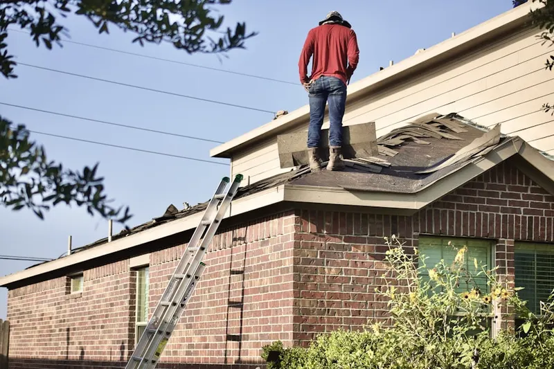 Professional roofer working on a residential roof in Hoskins